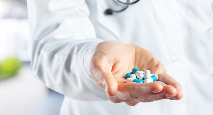 doctor-holding-pills_93675-130318